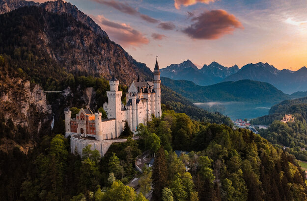 Panoramablick auf das Märchenschloss Neuschwanstein inmitten grüner Berge. Ein magischer Ort in Bayern.