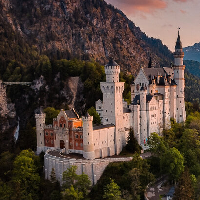 Panoramablick auf das Märchenschloss Neuschwanstein inmitten grüner Berge. Ein magischer Ort in Bayern.
