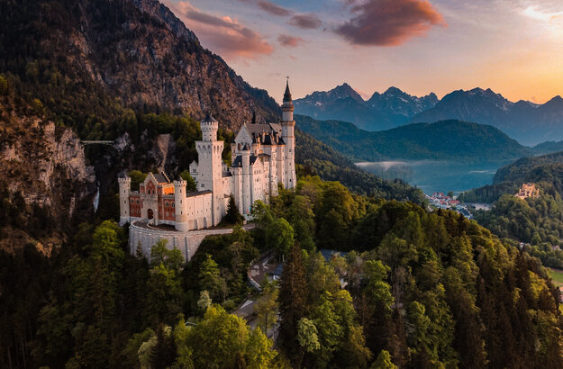Panoramablick auf das Märchenschloss Neuschwanstein inmitten grüner Berge. Ein magischer Ort in Bayern.