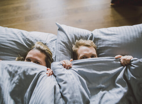 Ein Pärchen liegt im Bett.