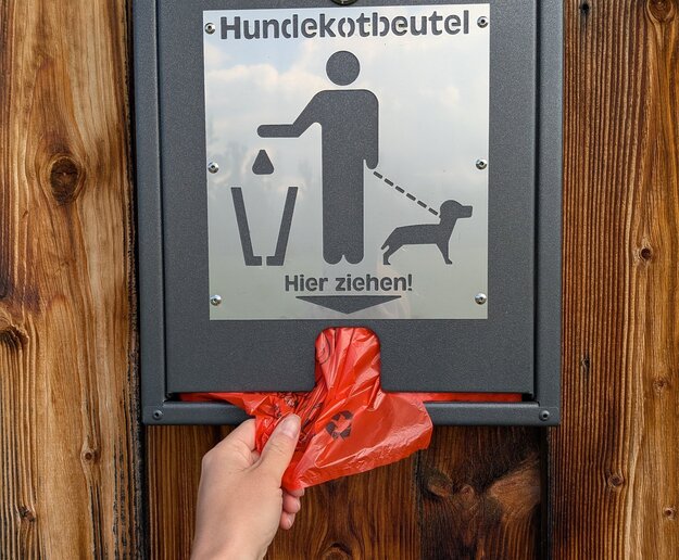 Das Bild zeigt eine Box mit Hundekotbeuteln.