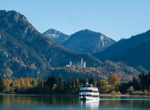 Rundfahrtschiff auf dem Forggensee mit Schloss Neuschwanstein und Alpengipfeln im Hintergrund