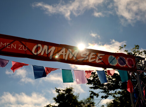 Zur Veranstaltungswebsite Banner am Eingang zum Festival "Om am See" in Füssen.