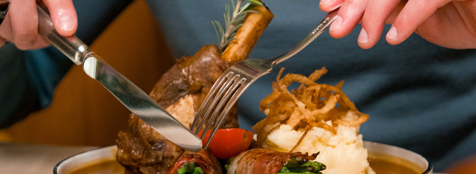 Ein Gast im Restaurant genießt eine Schweinshaxe in einem Füssener Restaurant