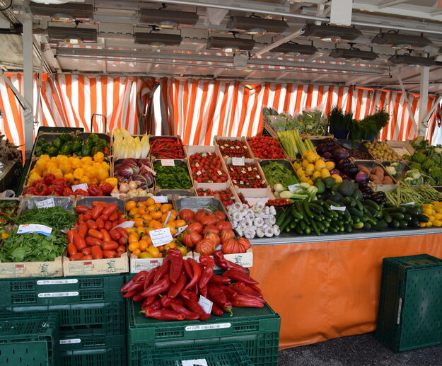 Ein lebendiger Marktstand bietet eine Fülle von Farben und Aromen mit einer beeindruckenden Auswahl an frischen Produkten. Die Fülle der Waren deutet auf eine reiche Ernte und eine lebendige Marktatmosphäre hin.