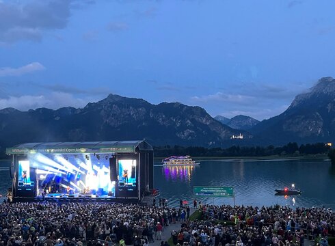 Das Foto zeigt die Seebühne der Königswinkel Open Airs am Forggenseeufer mit Publikum.