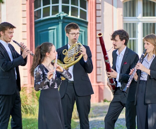 Das Bild zeigt ein fünfköpfiges Ensemble mit verschiedenen Musikinstrumenten.