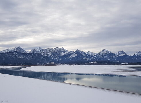 Winterliche Alpenkulisse bei Füssen mit dem Lech im Vordergrund.