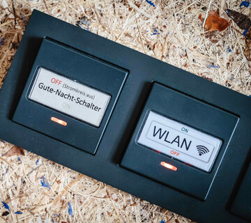 Das Bild zeigt einen Schalter, mit dem man über Nacht das WLAN und den Stromkreislauf ausschalten kann