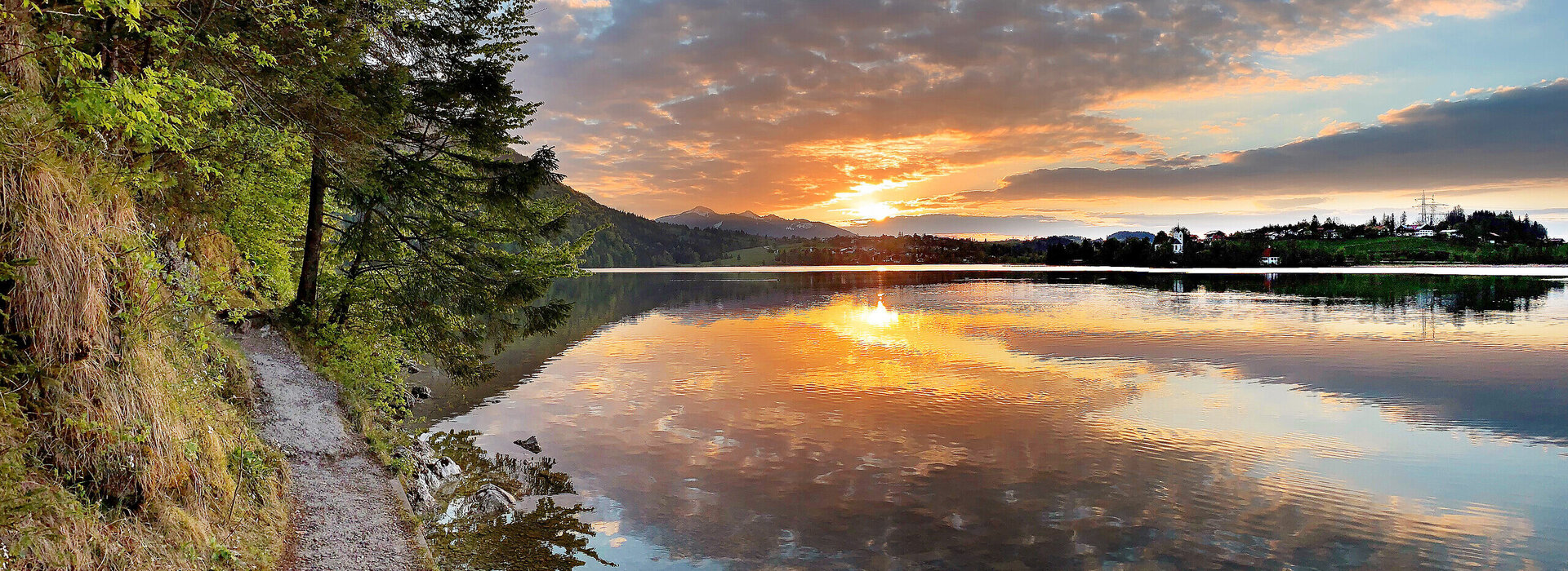 Das Bild zeigt den Weißensee Und den Füssener Ortsteil Weißensee im Abendlicht. 