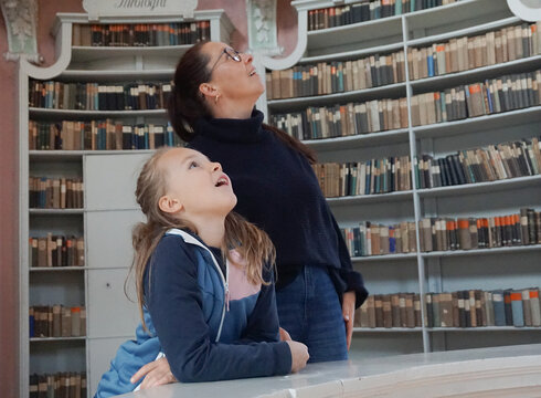 Eine Familie in der ehemaligen Klosterbibliothek von St. Mang (heute Museum der Stadt Füssen)