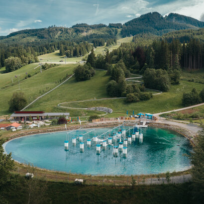 Das Bild zeigt ein Wasserbecken in einer bergigen Landschaft.