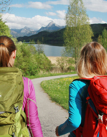 Zwei Frauen wandern am idyllischen Weißensee im Allgäu.