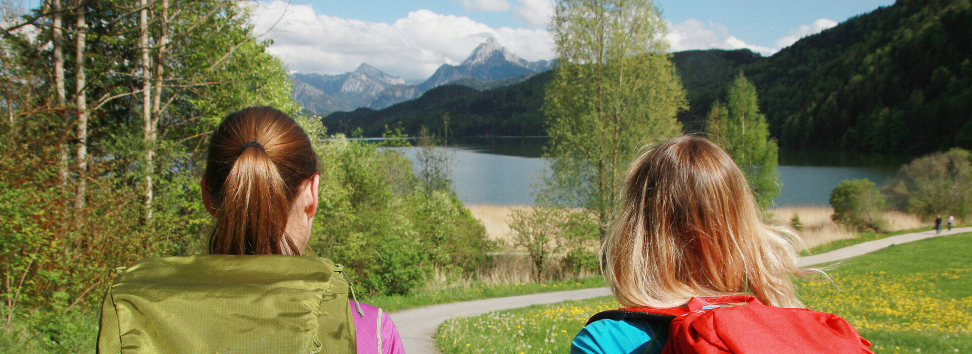 Zwei Frauen wandern am idyllischen Weißensee im Allgäu.