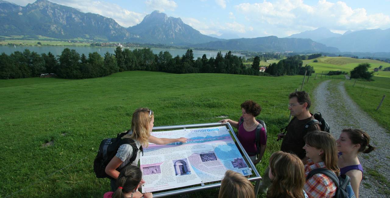 Geführte Wanderung für eine Gruppe mit Blick auf den Forggensee und die Berge