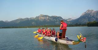 Geführte Drachenboot-Tour auf dem Forggensee mit Blick auf Schloss Neuschwanstein und die Berge